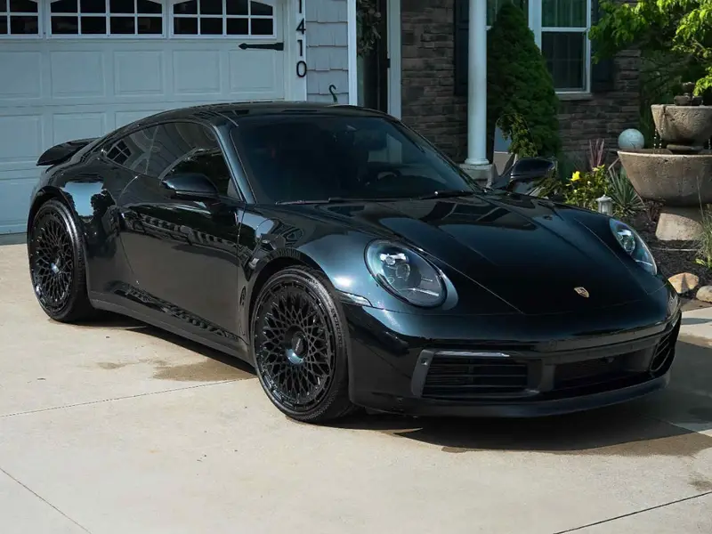 Black Porsche with professional ceramic coating for cars protection in driveway showing incredible gloss
