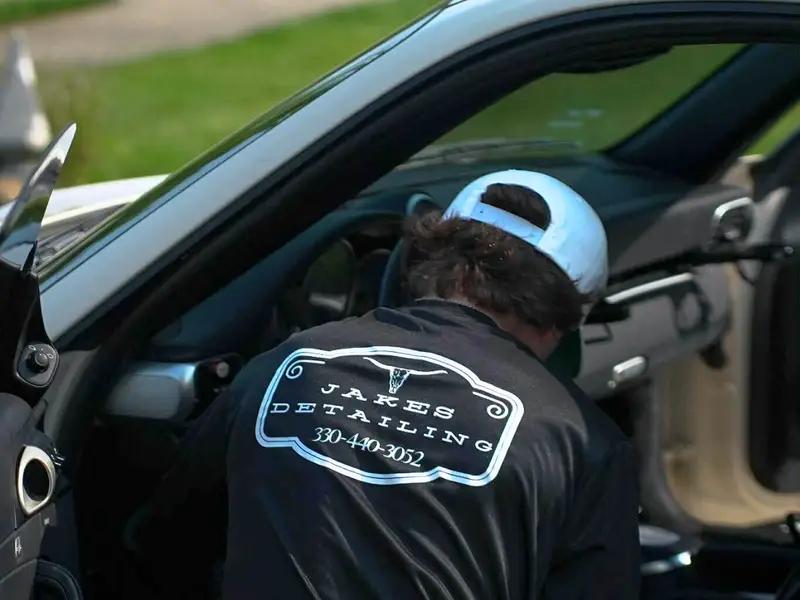 Professional technician working on car interior driver seat after detailed mobile cleaning